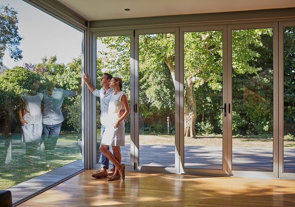 Full length of loving mid adult couple looking through glass window